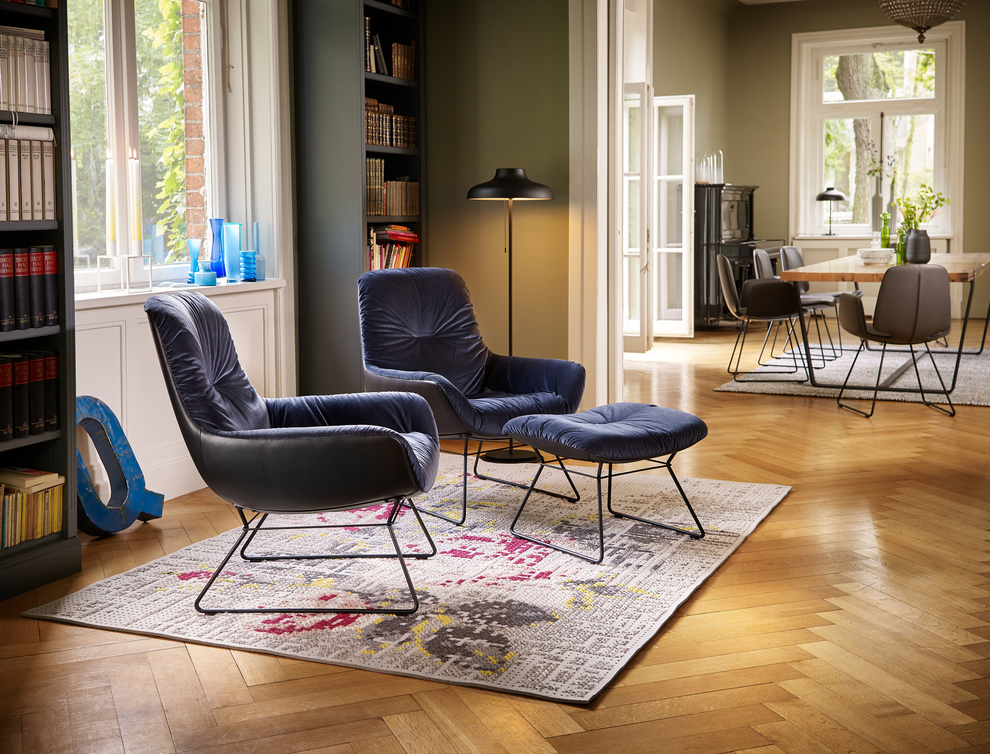 Blauer Leya Cocktail Sessel von Freifrau Manufaktur mit Hocker in stilvollem Wohnzimmer.