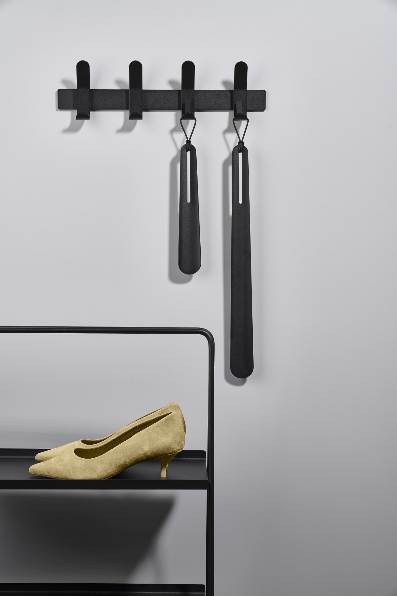 A-Table Regal von Zone Denmark mit Pumps und Schuhanziehern an der Wand.