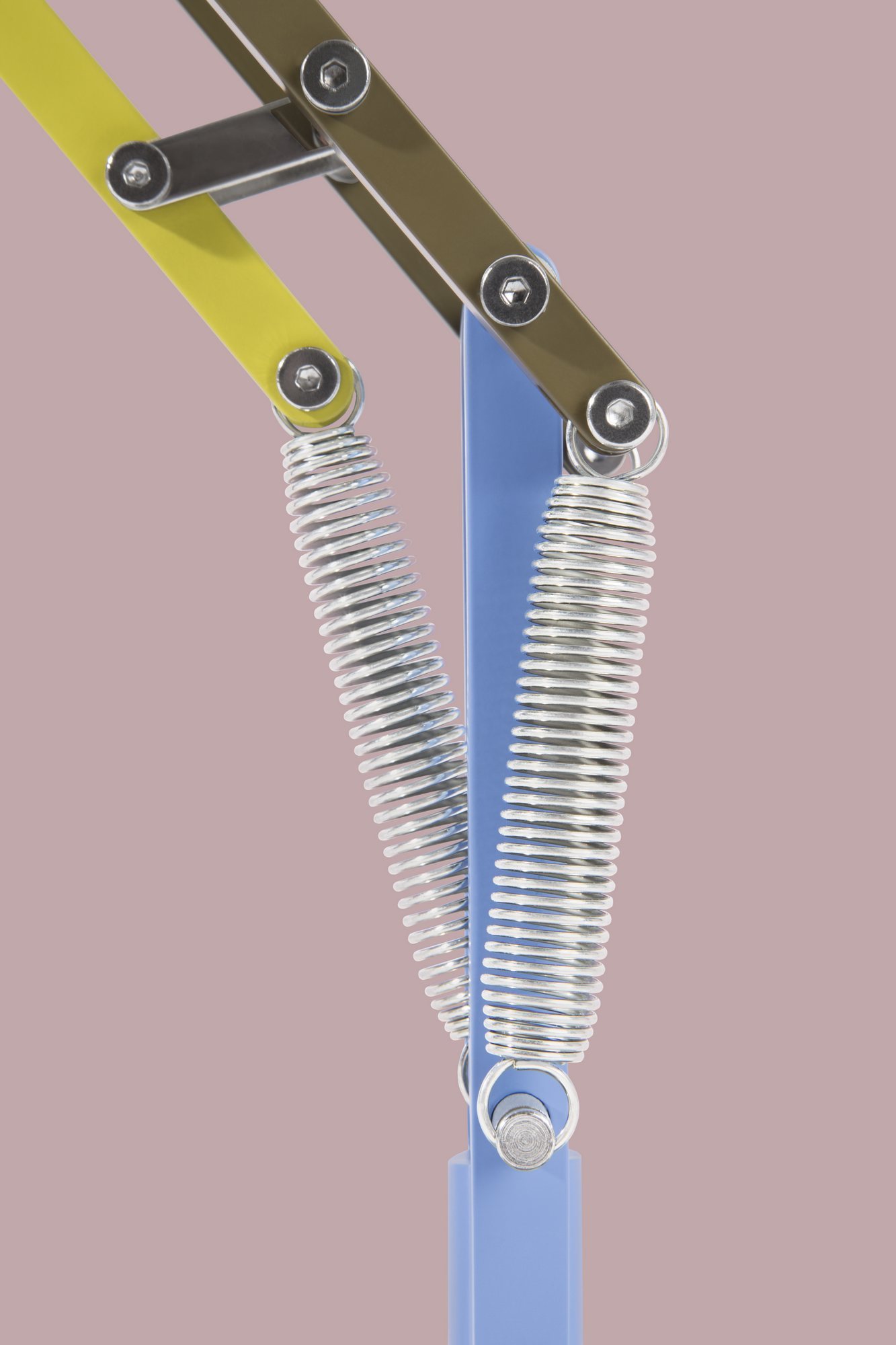 Detailaufnahme der Anglepoise Type 75 Paul Smith Edition Tischleuchte, die Federn und Gelenke in Gelb, Blau und Olivgrün zeigt.