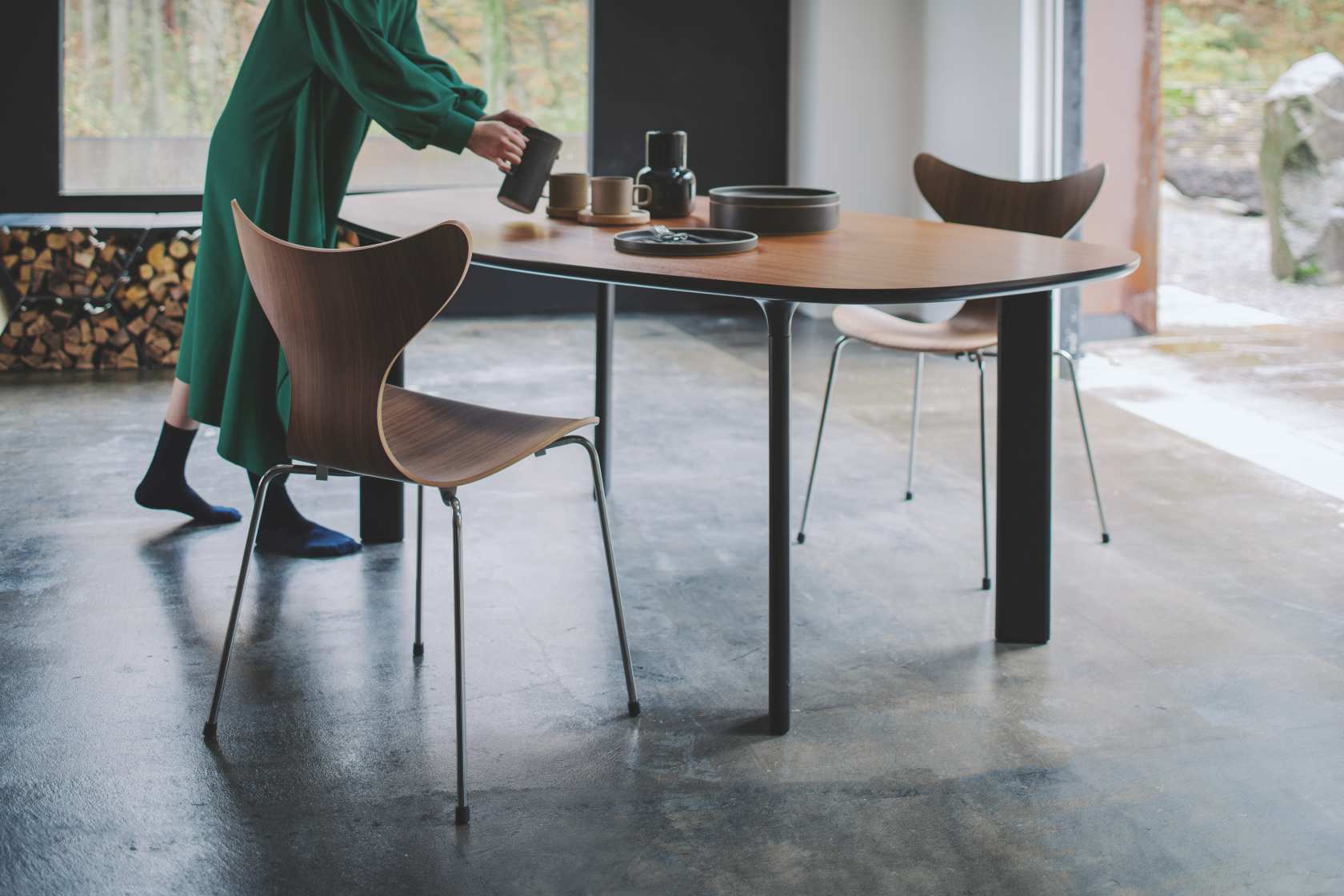 Lily Stuhl von Fritz Hansen am Esstisch, skandinavisches Design mit Holzschale und Stahlbeinen.
