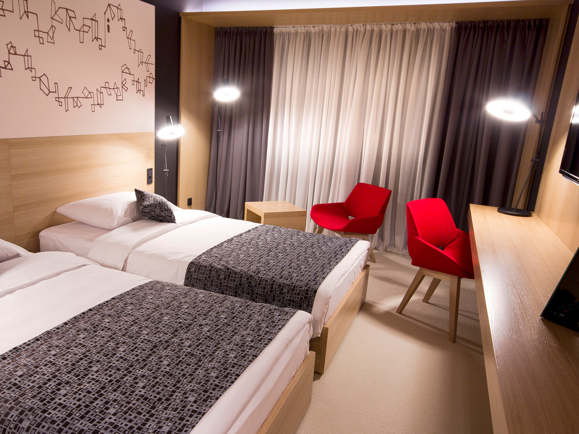 Zwei Betten im Hotelzimmer mit Arigato Stehleuchte von Grupa im Hintergrund. Designlampe spendet Licht.
