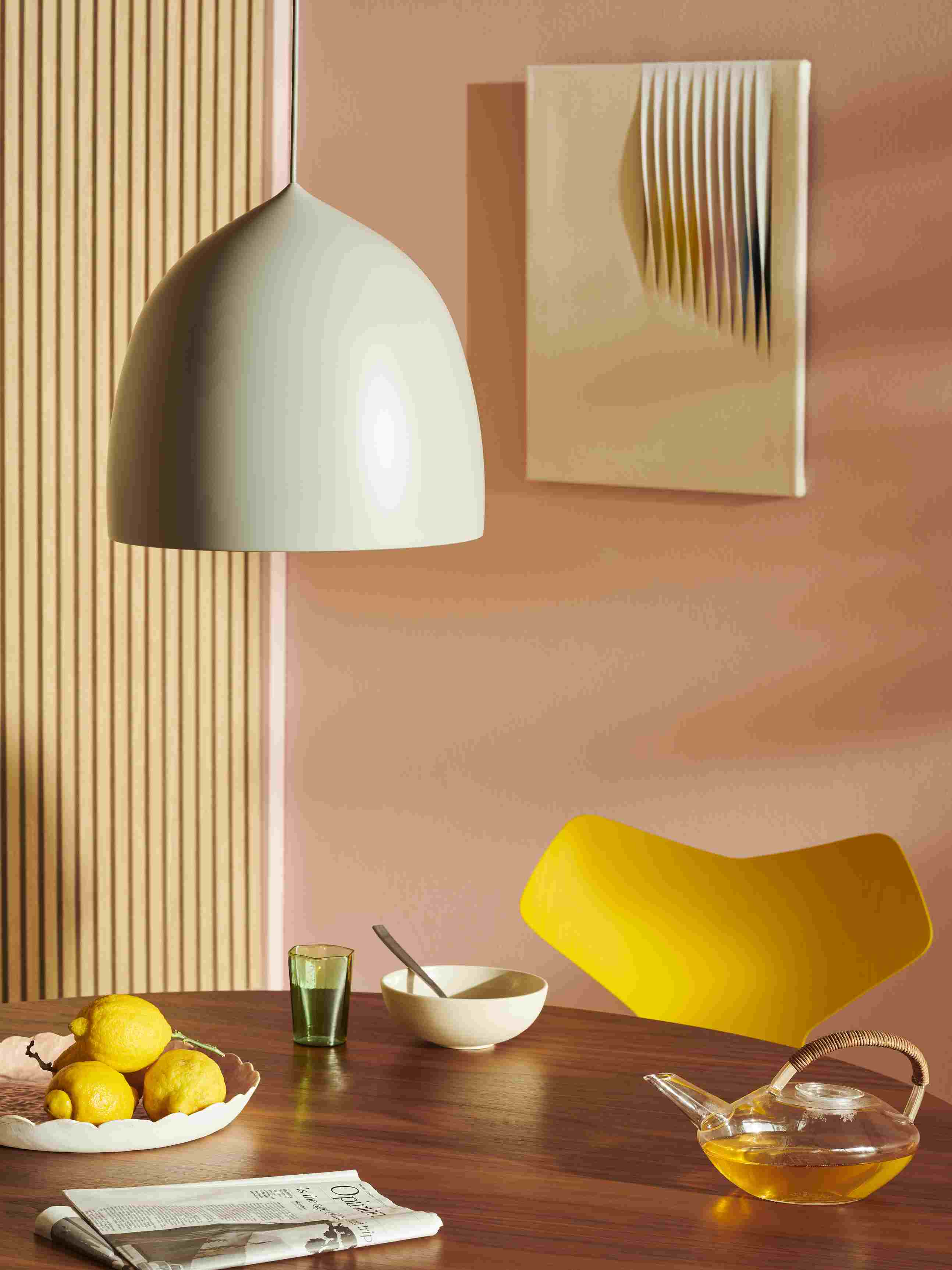 Gelber Grand Prix Stuhl von Fritz Hansen am Esstisch mit Teekanne und Zitronen.