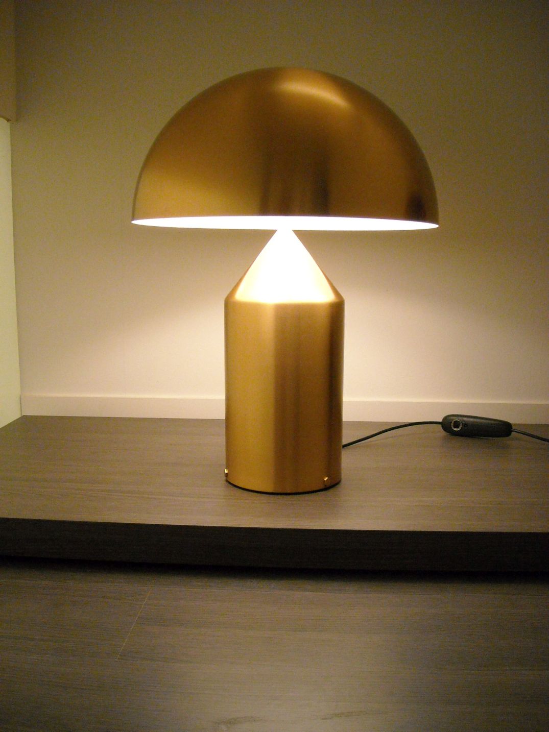 Goldene Atollo Tischleuchte von Oluce, modernes Designobjekt für Wohnzimmer und Schlafzimmer, stimmungsvolle Beleuchtung.