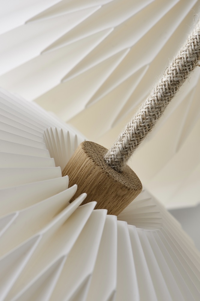 Detailaufnahme des Le Klint THE BOUQUET Kronleuchters mit drei Lampenschirmen aus weißer Folie und Holzelement.