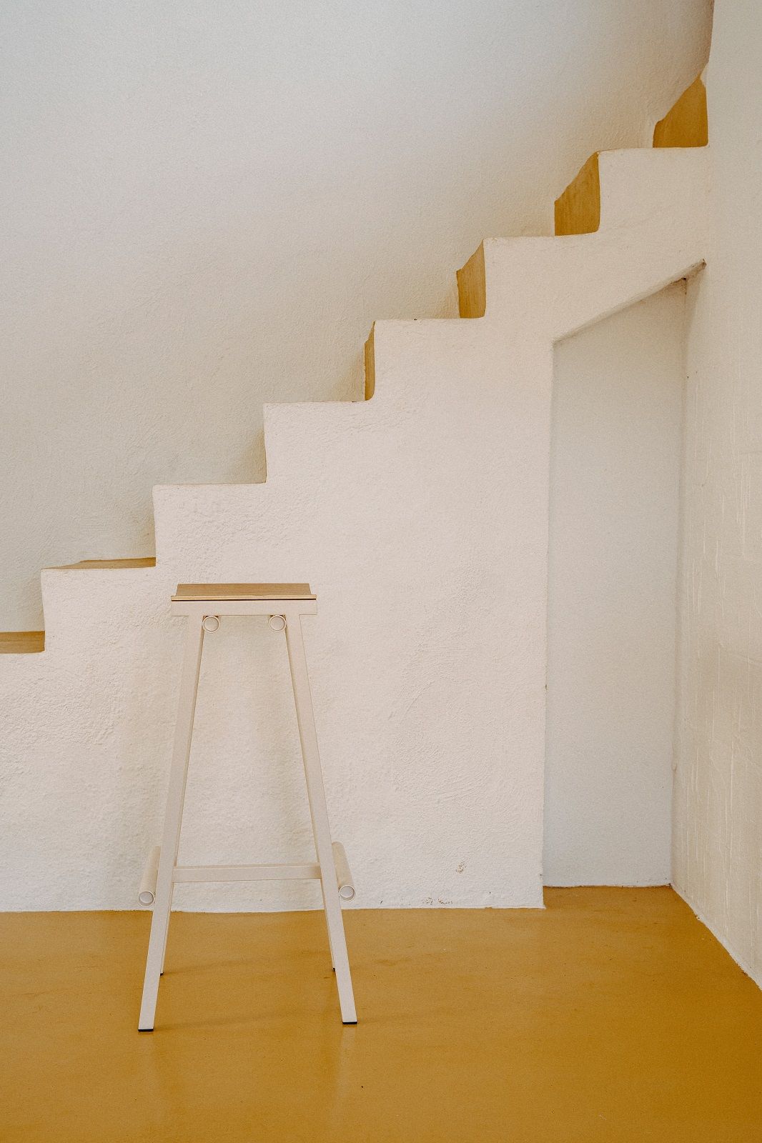 Heller Taburete 8 Bar Stool Barhocker von Hay vor einer Treppe in minimalistischem Interieur.