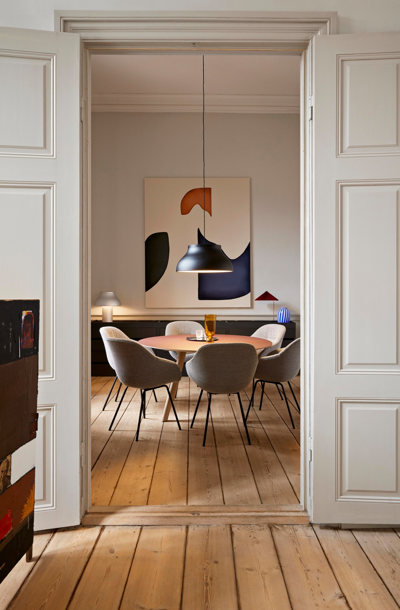 Esszimmer mit rundem Tisch und sechs grauen About a Chair AAC127 Stühlen von Hay.