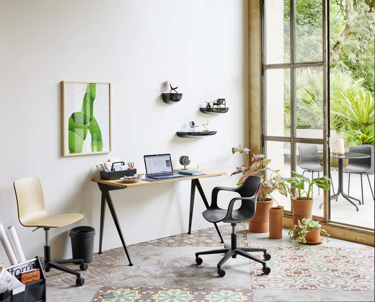 Schwarze Vitra Night Clock Tischuhr auf einem Schreibtisch in einem modern eingerichteten Arbeitszimmer mit Pflanzen.