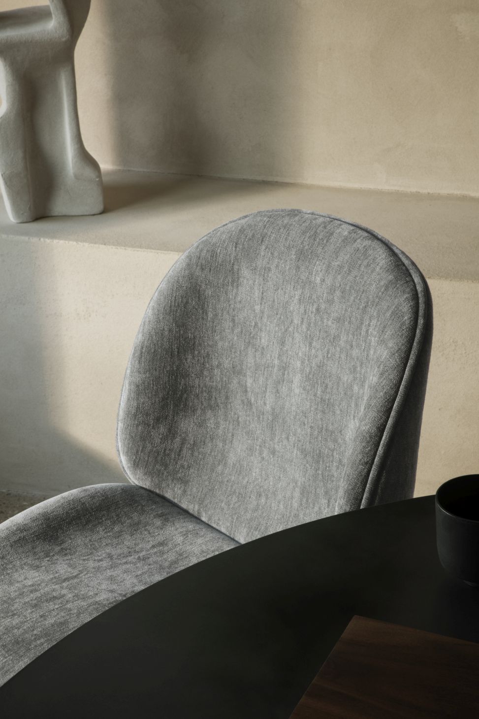 Detailaufnahme: Grauer Stuhl am Epic Esstisch von Gubi mit Stahlgestell, modernes Möbeldesign.