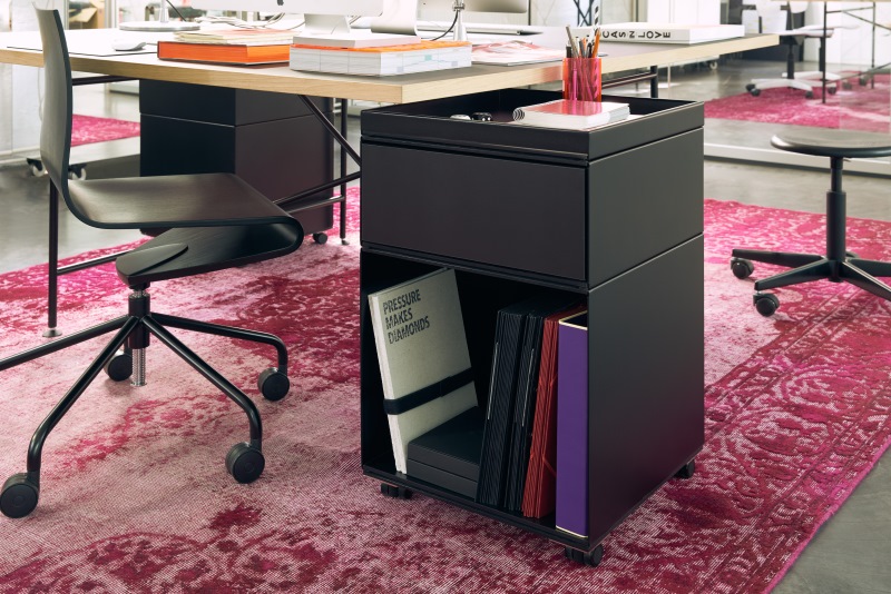 Schwarzer Rollcontainer mit Schublade und offenem Fach für Bürobedarf und Aktenordner im modernen Büro.