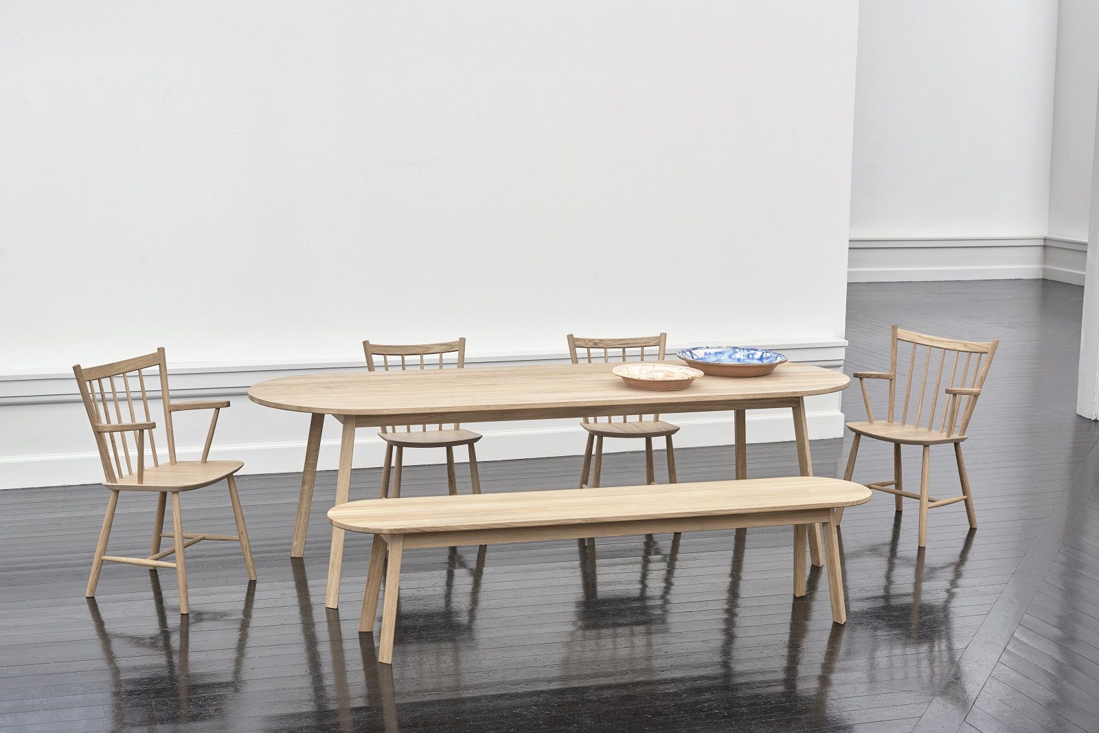 Hay Triangle Leg Table Esstisch aus Eiche mit Stühlen und Bank in minimalistischem Esszimmer.