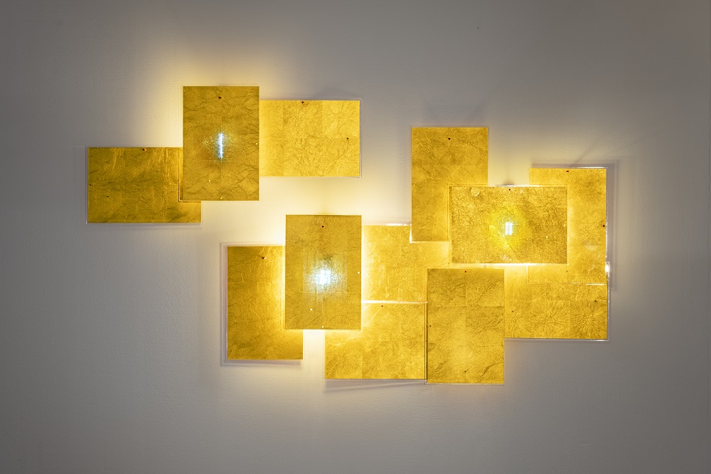 Detailaufnahme der 24 Karat Blau Wandleuchte von Ingo Maurer mit goldenen, rechteckigen Elementen.