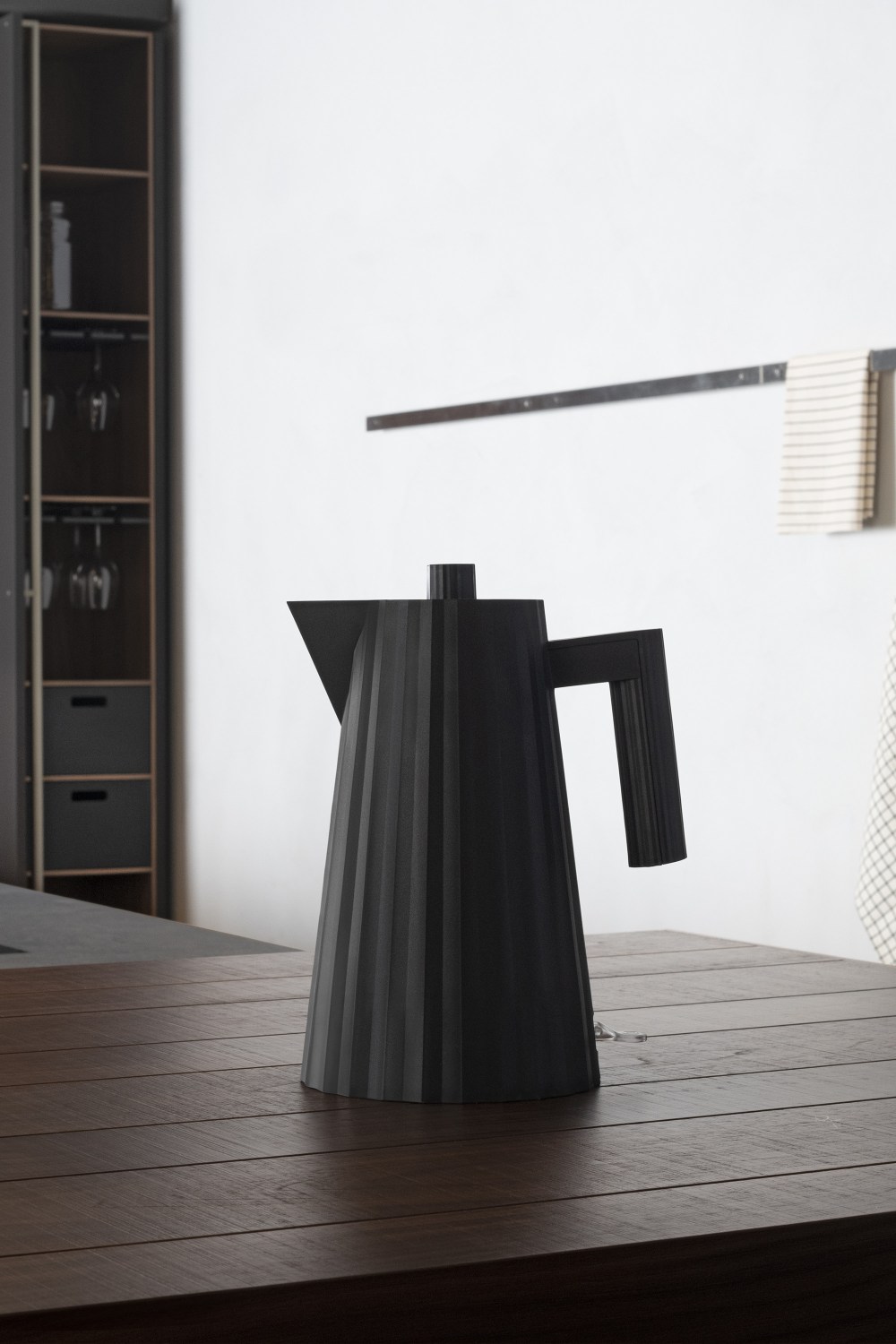 Schwarzer Alessi Plissé Wasserkocher auf Holztisch. Design Wasserkocher für Küche und Haushalt.