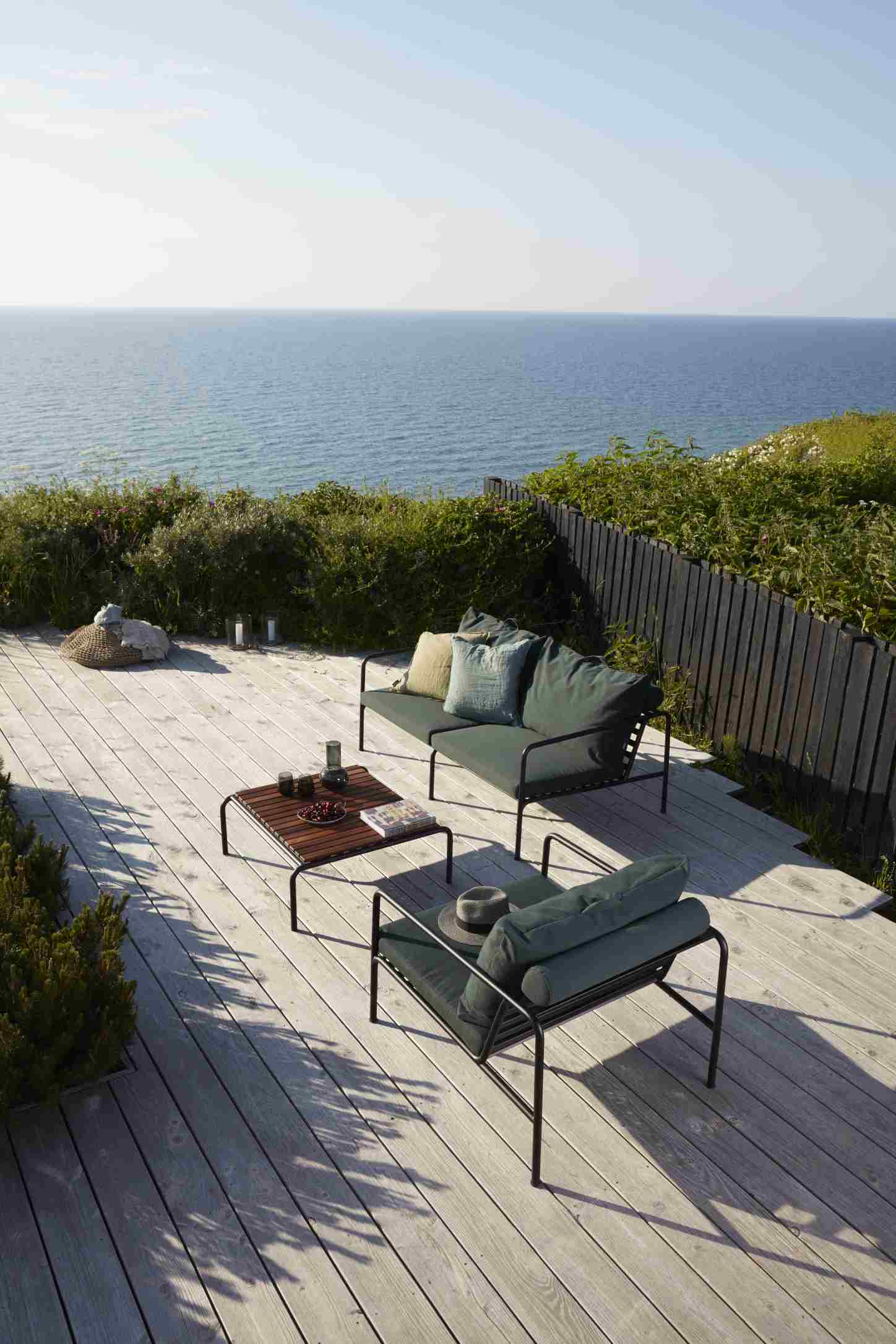 Avon 2-Sitzer Outdoor Sofa von Houe auf Holzterrasse mit Meerblick, stilvolle Gartenmöbel und Lounge-Atmosphäre.