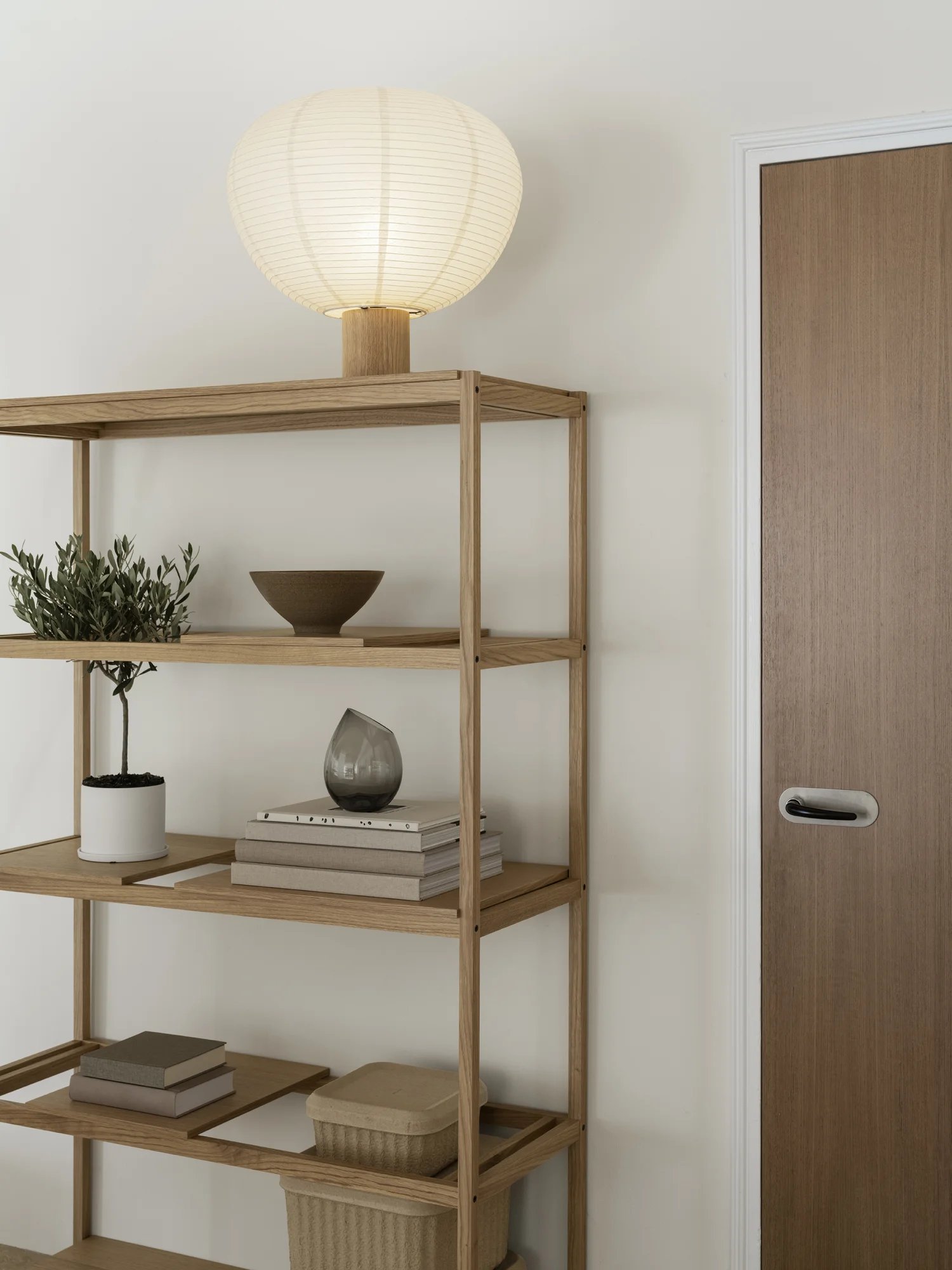 Blomus Kami Reispapier Tischleuchte auf Holzregal, sanftes Licht, minimalistisches Design für Wohnzimmer und Schlafzimmer.