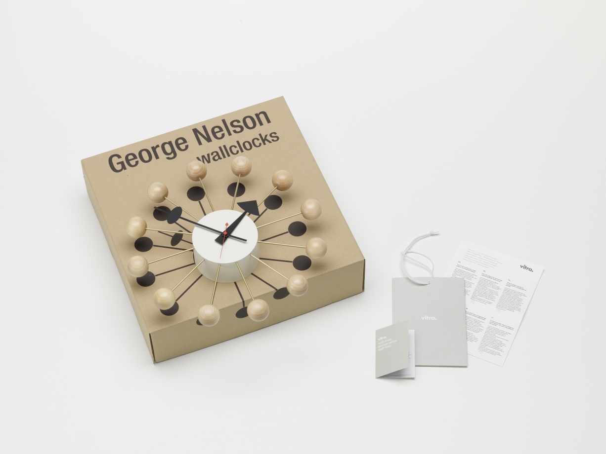 Vitra Ball Clock Wanduhr aus Buchenholz, eine moderne Design-Uhr auf einem Karton.