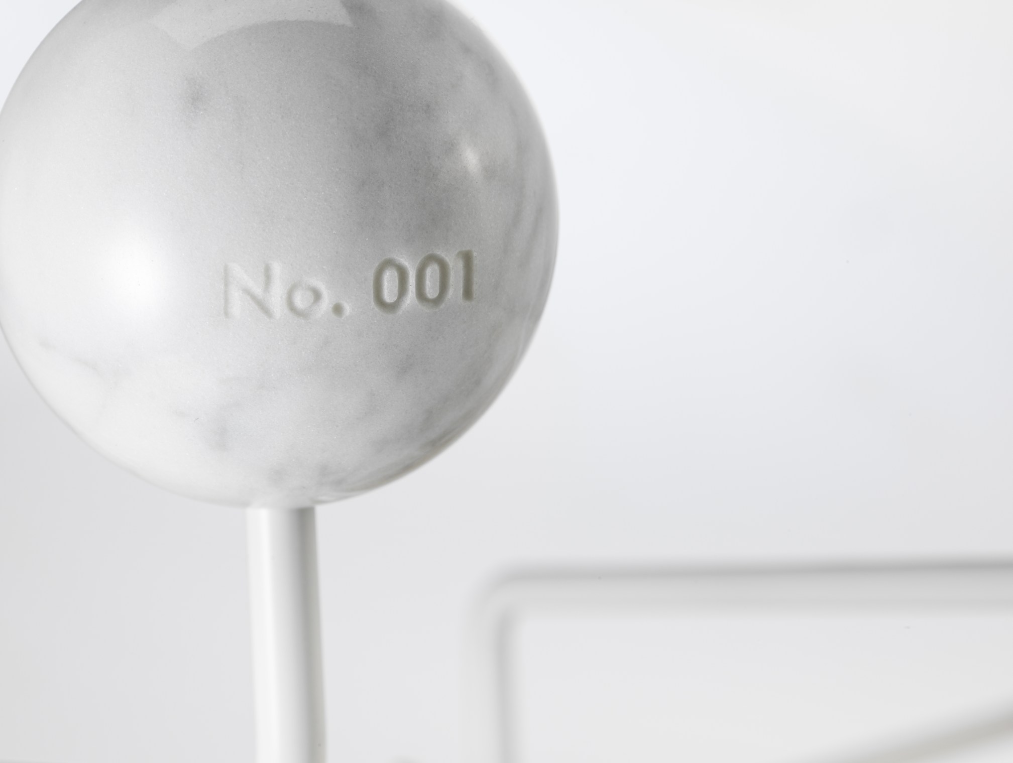 Detailaufnahme einer Marmorkugel der Eames Hang it all Garderobe Limited Edition, Nummer 001.