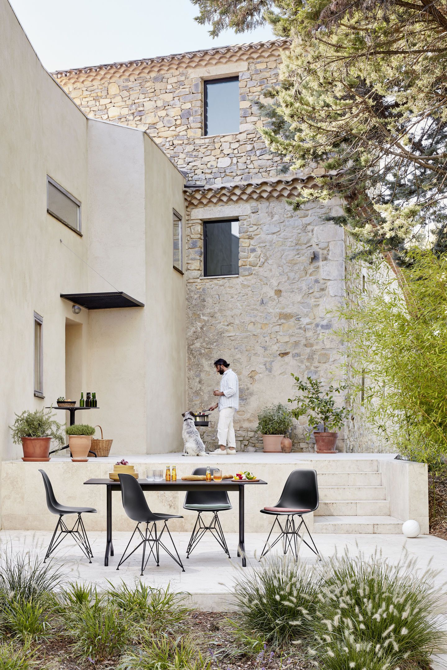 Eames Fiberglass Chair DSR Stuhl von Vitra mit Sitzpolster am Esstisch im Garten.