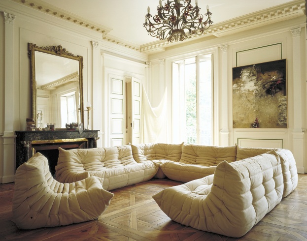 Beige Togo Sofa von Ligne Roset in einem eleganten Wohnzimmer mit Parkettboden und Kamin.