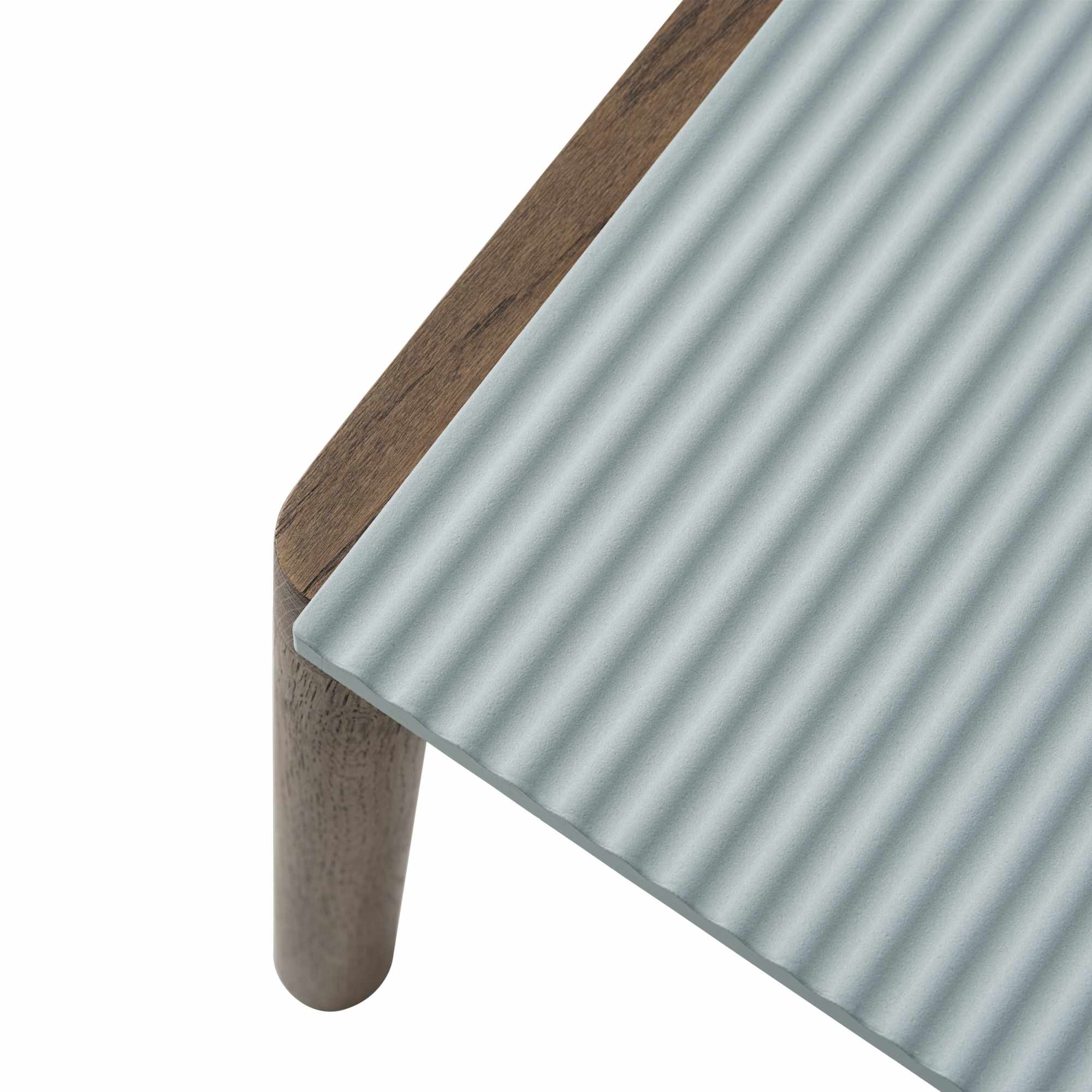 Detailaufnahme des Muuto Couple Coffee Table: Holzrahmen, geriffelte, hellblaue Tischplatte und ein Tischbein.