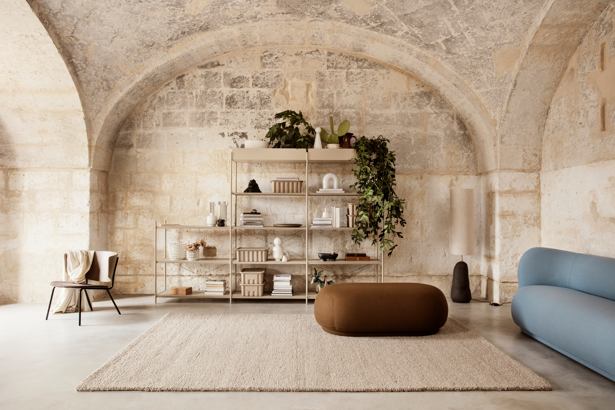 Nahaufnahme der Ferm Living Vuelta Lampe Tischleuchte in einem stilvollen Wohnzimmer mit Regalen und Dekoration.