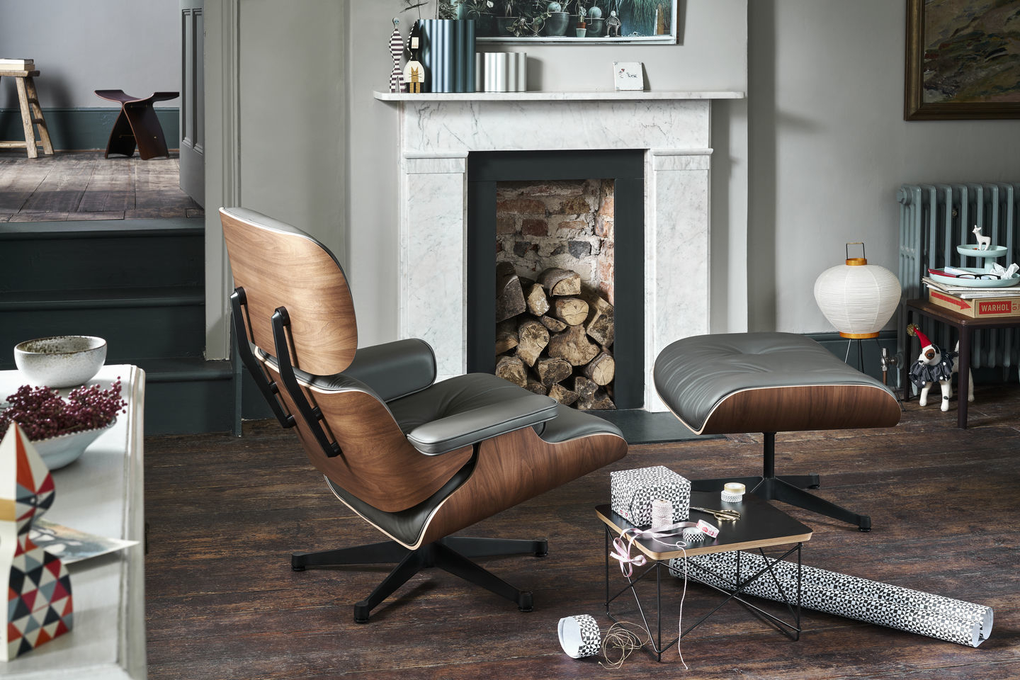 Wohnzimmer-Szene mit Vitra Eames Lounge Chair und Ottoman in Nussbaum und schwarzem Leder.