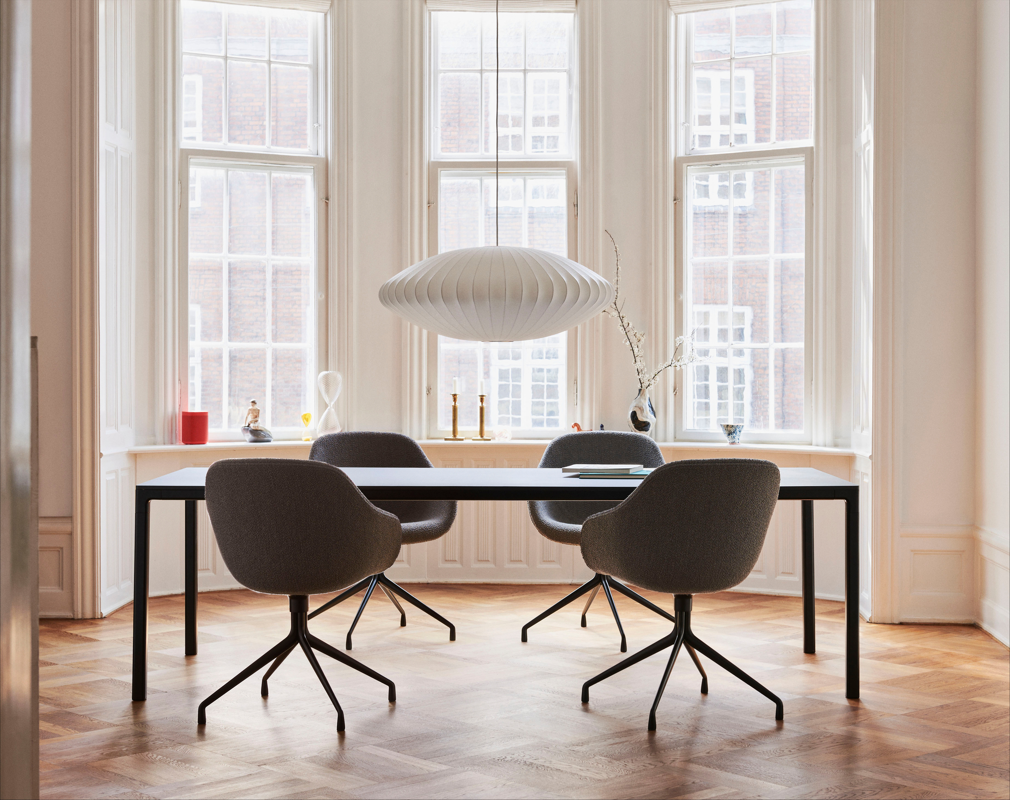 Esszimmer mit schwarzem Tisch und vier grauen About a Chair AAC121 Soft Duo Stühlen von Hay.