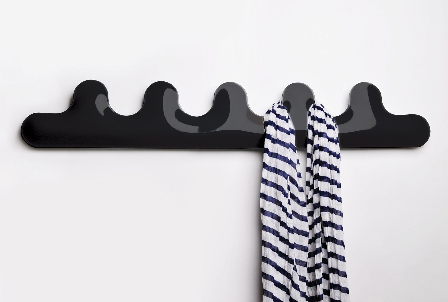 Schwarze Kamm Garderobe von Zieta mit einem gestreiften Schal an der Wand befestigt. Moderne Wandgarderobe für Flur und Diele.