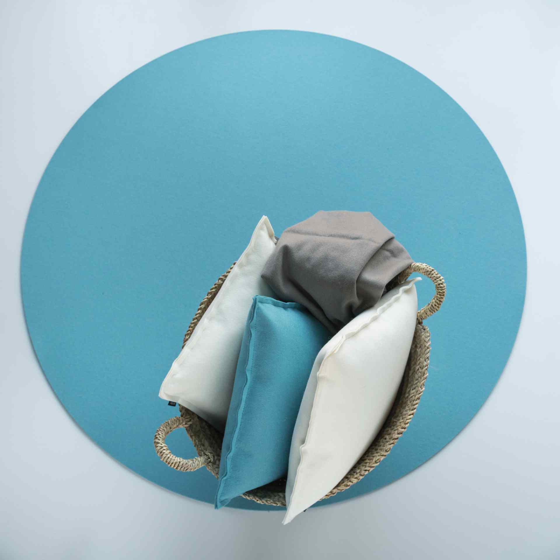Blauer, runder Bigdot Teppich von HEY-SIGN mit Kissen in einem Korb, modernes Wohnaccessoire.