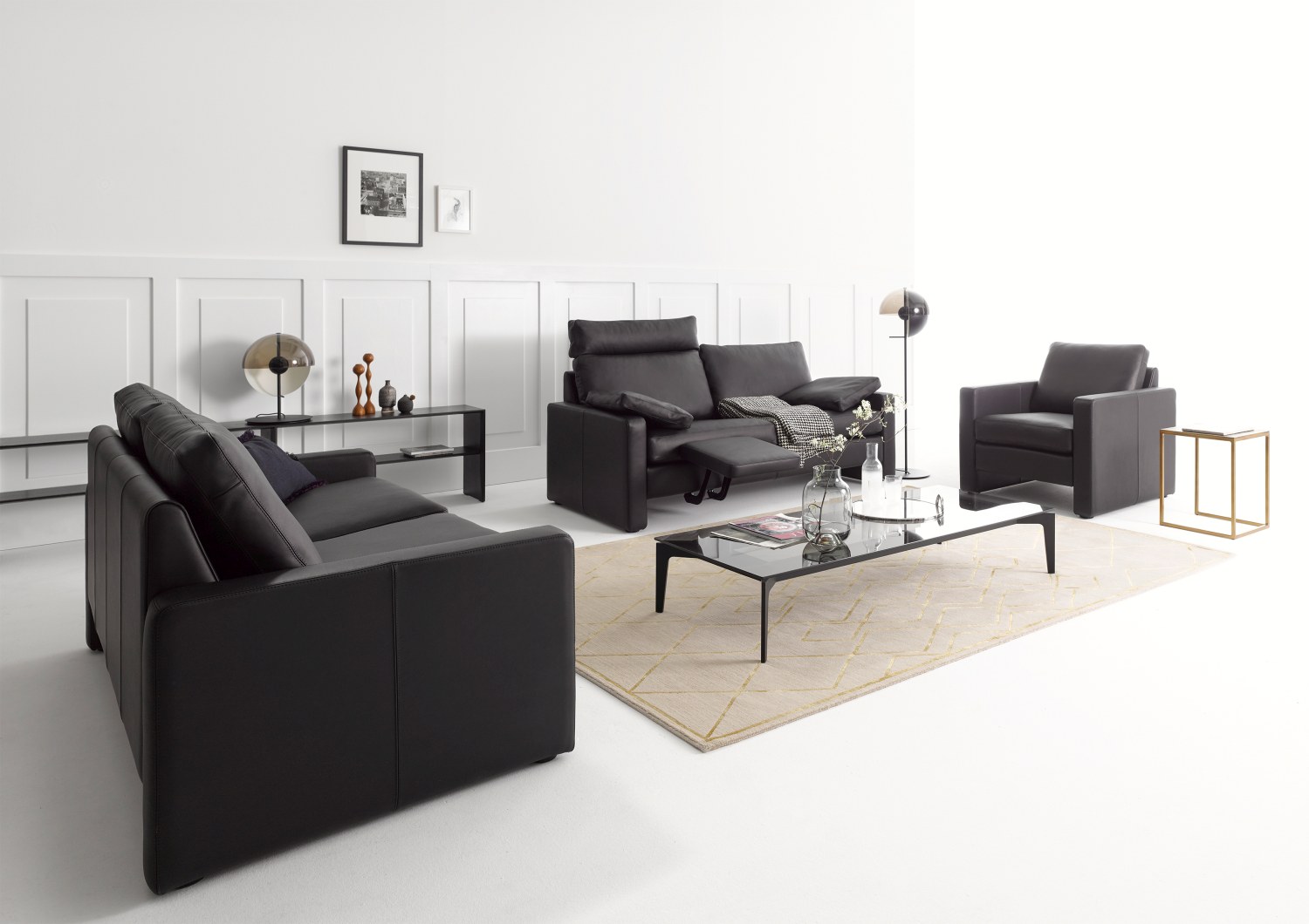 Schwarze Conseta Sofa Konfiguration Cor mit Sessel und Couchtisch in modernem Wohnzimmer Ambiente.