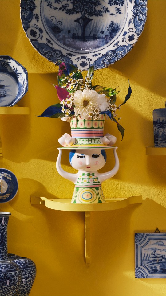 Bjorn Wiinblad Lady with Hat Vase, dekorative Keramik Blumenvase mit Blumen auf gelbem Regal.
