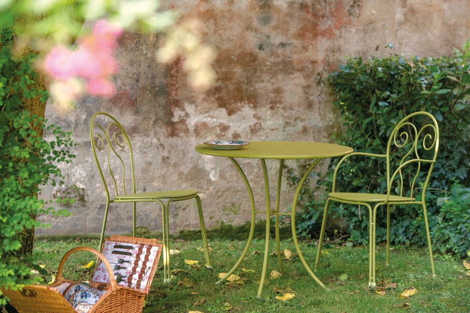 Caprera Stuhl von Emu, Gartenset in Grün mit Tisch und Picknickkorb im Garten.