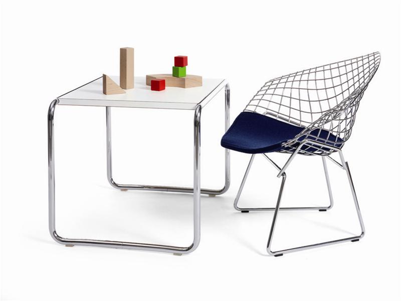 Weißer Laccio Couchtisch klein von Knoll International mit Spielzeug und einem Drahtsessel.