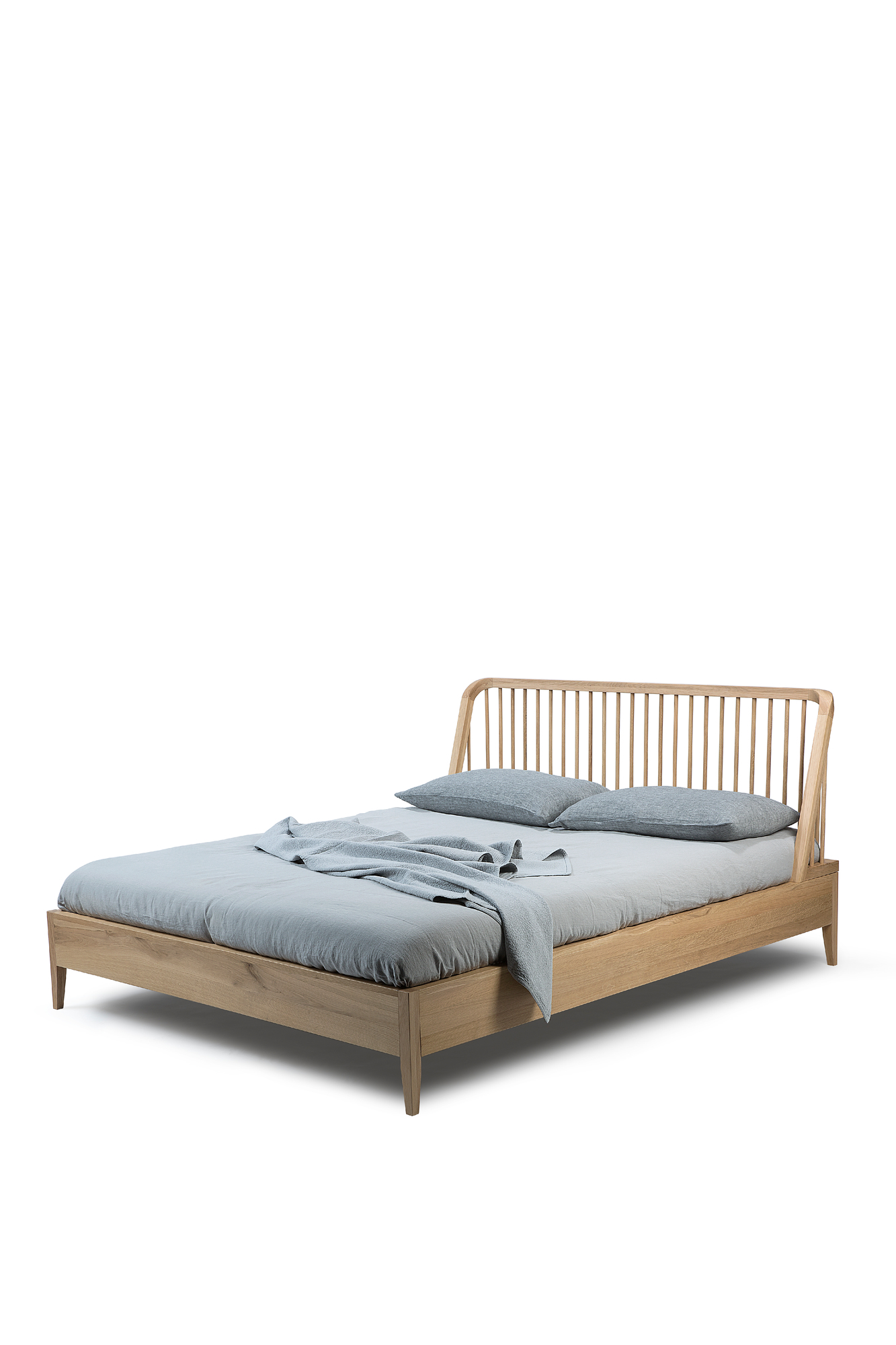 Ethnicraft Spindle Bett aus Eiche mit Lattenrost und blauer Bettwäsche. Modernes Design für Schlafzimmer.