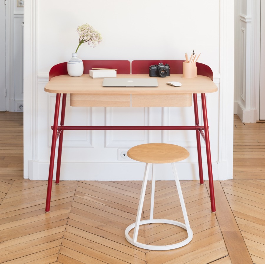 Moderner Holzschreibtisch mit roten Beinen und passendem Hocker. Ideal für Homeoffice und Arbeitszimmer.