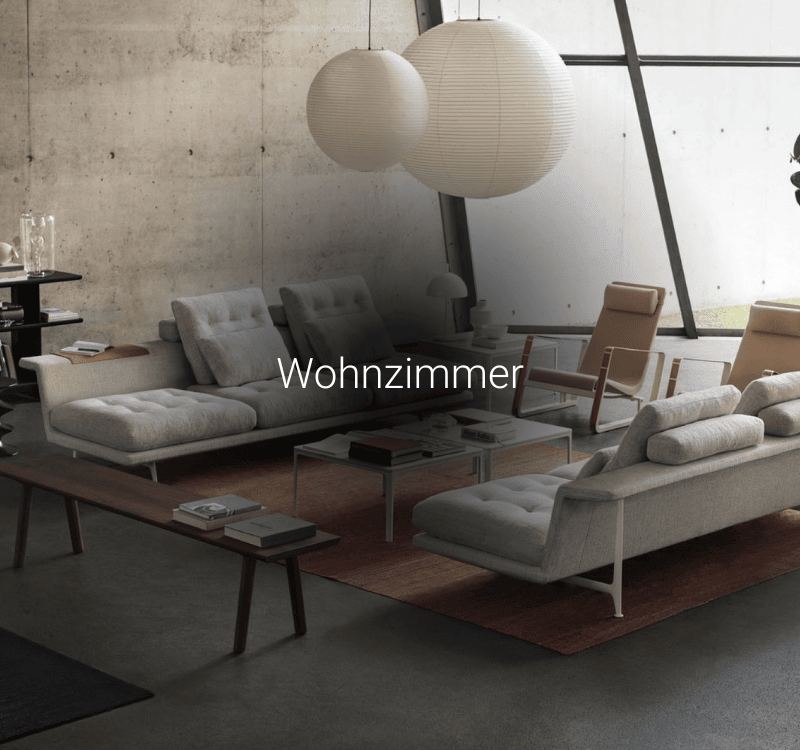 Heller Wohnraum mit modernem Sofa, Lounge-Sesseln, Couchtisch und Papierleuchten für stilvolles Wohnen.