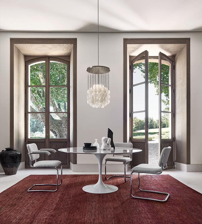 Esszimmer mit rundem Marmortisch, Design-Stühlen, Muschel-Hängeleuchte und rotem Teppich für stilvolles Wohnen.