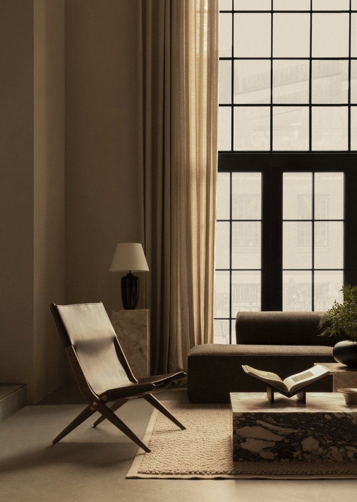 Elegantes Wohnzimmer mit braunem Ledersessel, Sofa, Marmortisch und Vorhängen für stilvolles Wohnen.