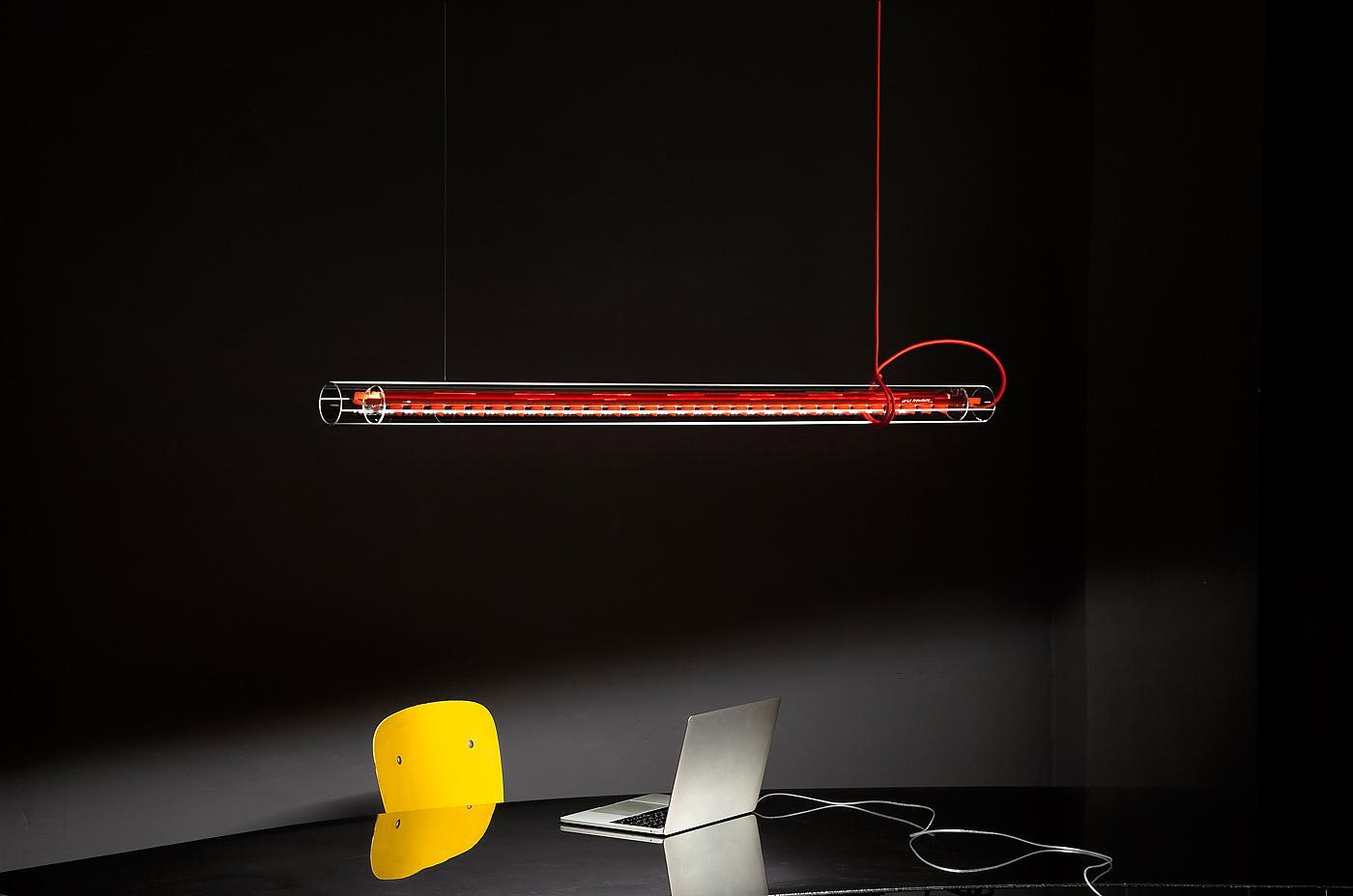 Ingo Maurer Tubular LED Hängeleuchte mit rotem Kabel über Schreibtisch mit Laptop und Stuhl.