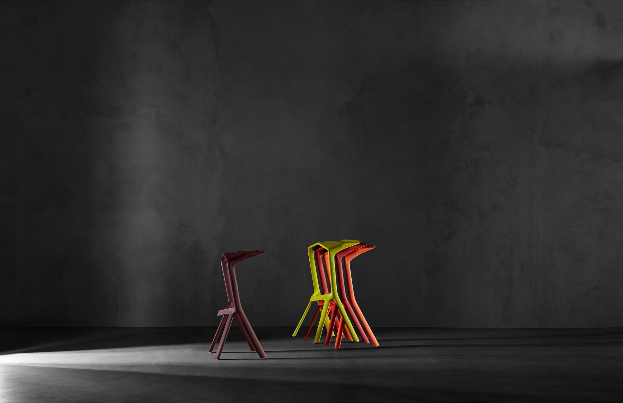 Miura Barhocker von Plank, stapelbar, in verschiedenen Farben vor dunklem Hintergrund. Design Hocker.