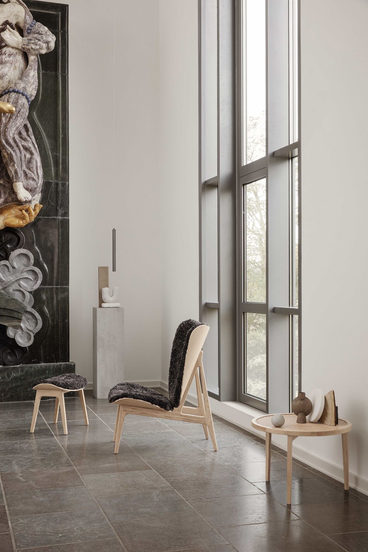NORR11 Elephant Hocker und Sessel mit dunklem Fellbezug in stilvollem Interieur.