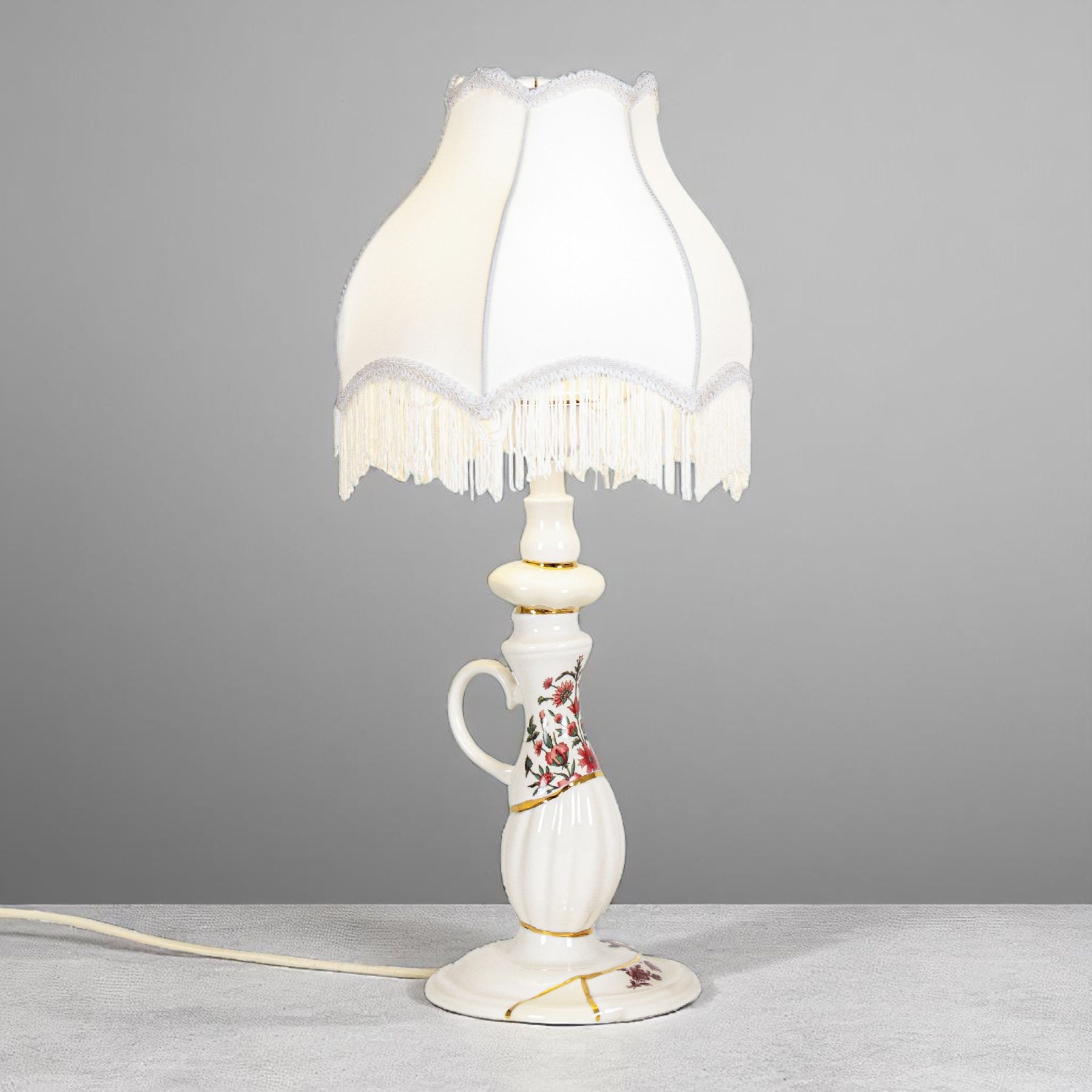  Kintsugi Abat-Jour Tischleuchte von Seletti mit weißem Lampenschirm und floral verziertem Keramikfuß im Kintsugi-Stil.