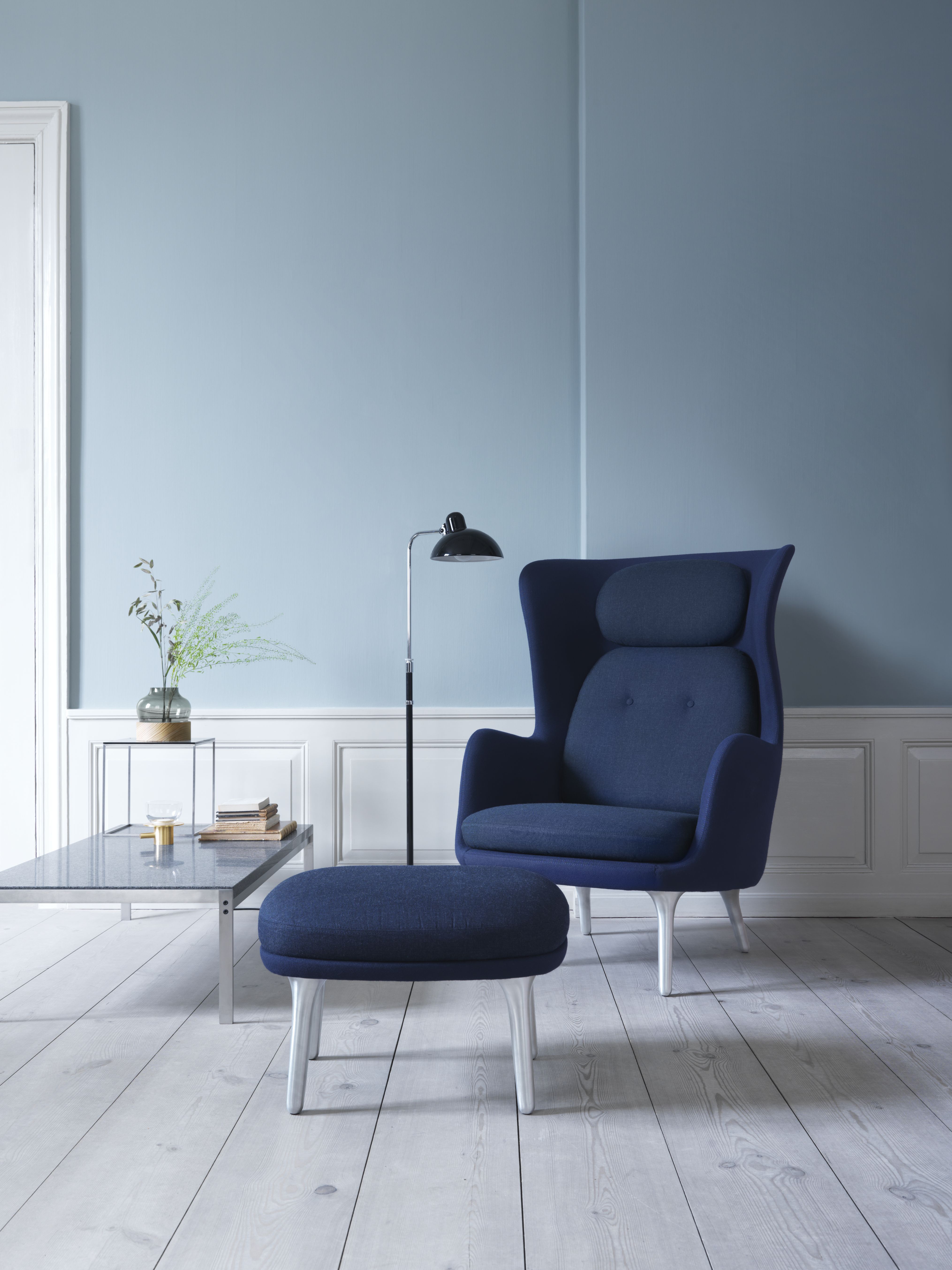 Blauer Ro Sessel von Fritz Hansen mit Aluminiumfuß und passendem Hocker im Wohnzimmer.