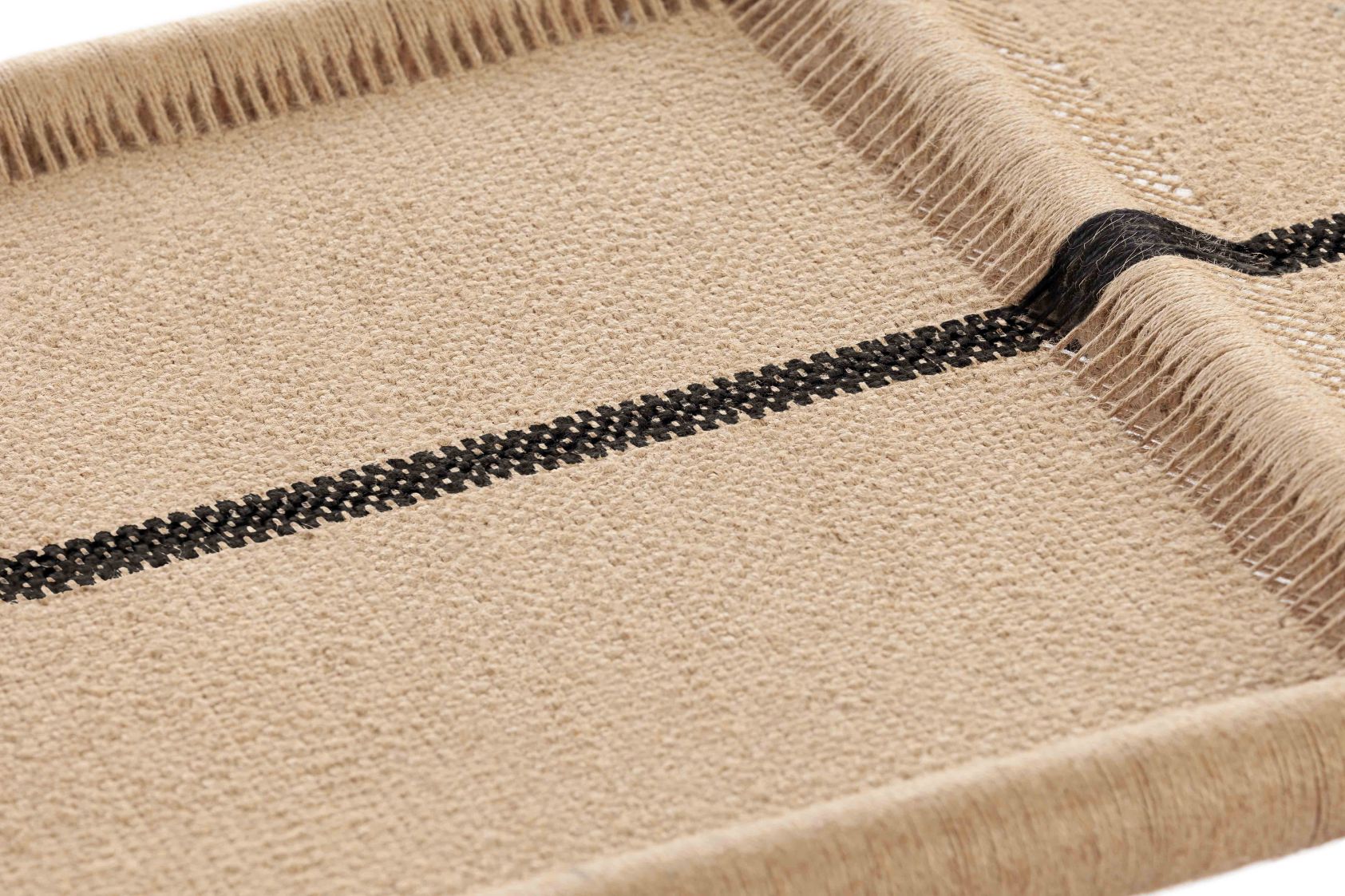 Detailaufnahme der Roots Bank: Beige Oberfläche mit schwarzem Streifen und Fransen.