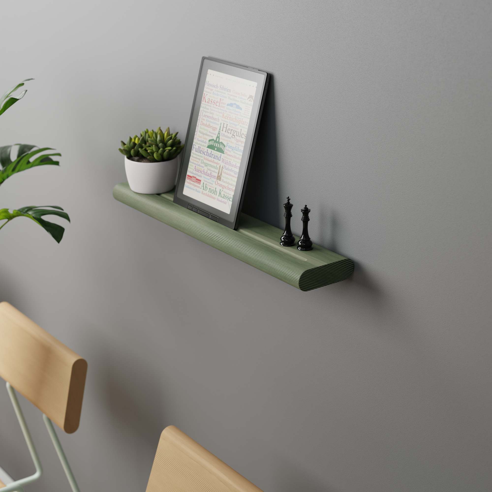 Waldgrünes Wandregal mit Deko: Sukkulente, E-Reader und Schachfiguren. Holzregal für Wohnzimmer und Büro.