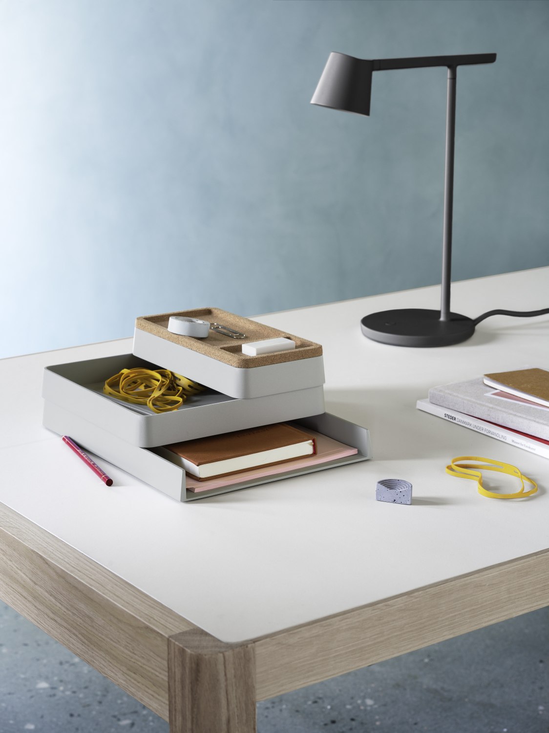 Muuto Arrange Desktop Serie Konfiguration 1: Schreibtisch-Organizer mit Ablagefächern, Stifthalter und Büromaterial auf einem Schreibtisch.