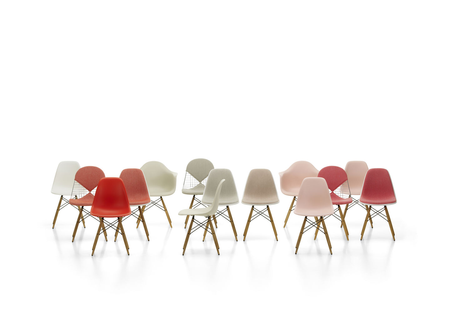 Gruppe von Vitra Stühlen, darunter DKW Wire Chair und Eames Plastic Chairs mit Sitzkissen.