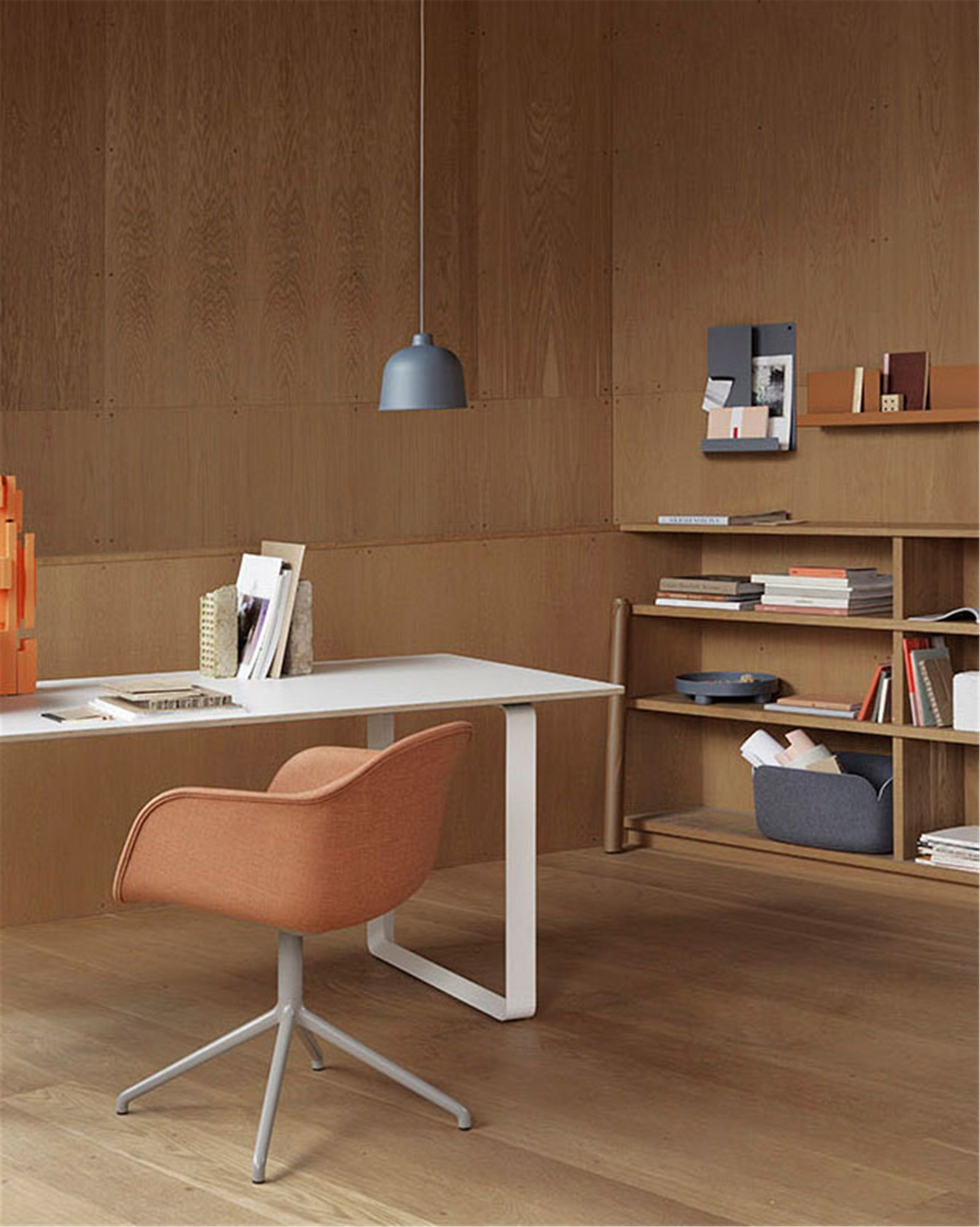 Nahaufnahme der grauen Muuto Grain Pendelleuchte über einem modernen Schreibtisch in einem Büro.