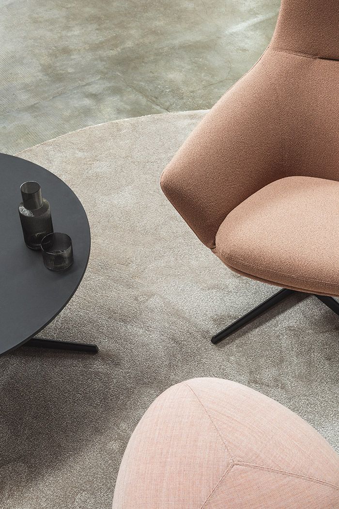 Nahaufnahme: Wing Tip S281 Lounge Sessel in Rosa mit schwarzem Tisch und Hocker auf Teppich.
