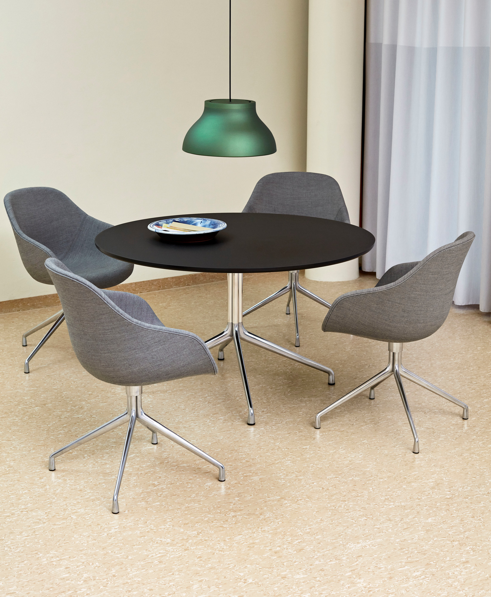 Esstisch mit vier grauen About a Chair AAC 121 Stühlen und grüner Pendelleuchte.