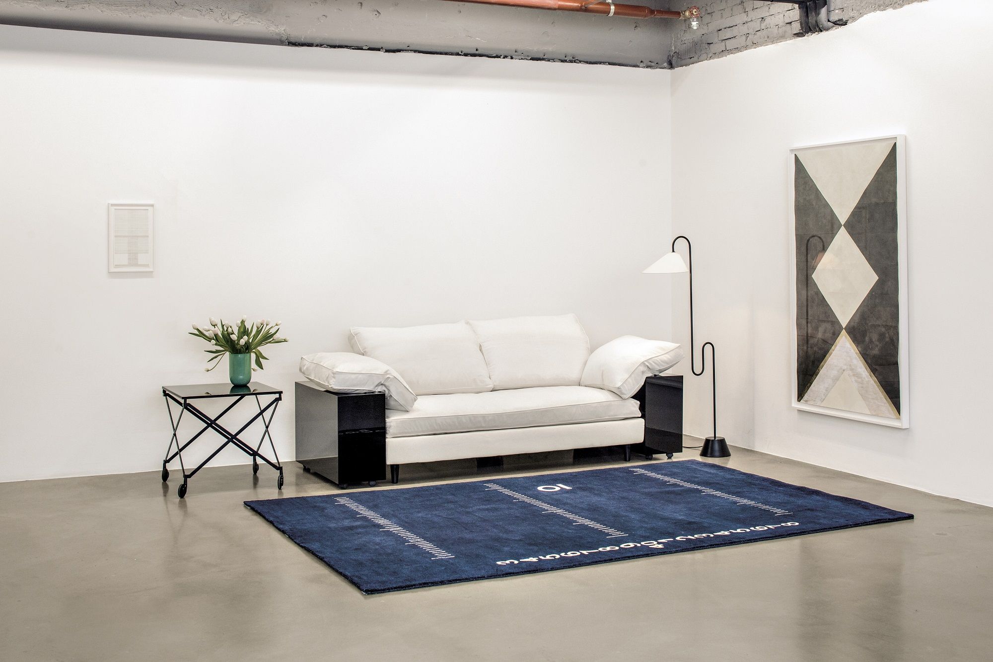 Helles Lota Sofa von Classicon in modernem Wohnraum mit blauem Teppich und Kunst.